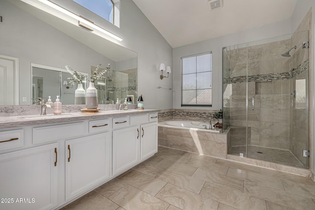 full bathroom with a healthy amount of sunlight, double vanity, a shower stall, vaulted ceiling, and a bath