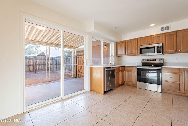 kitchen featuring sink, light tile patterned floors, and appliances with stainless steel finishes