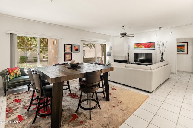 dining area with light tile patterned flooring, a wealth of natural light, and ceiling fan