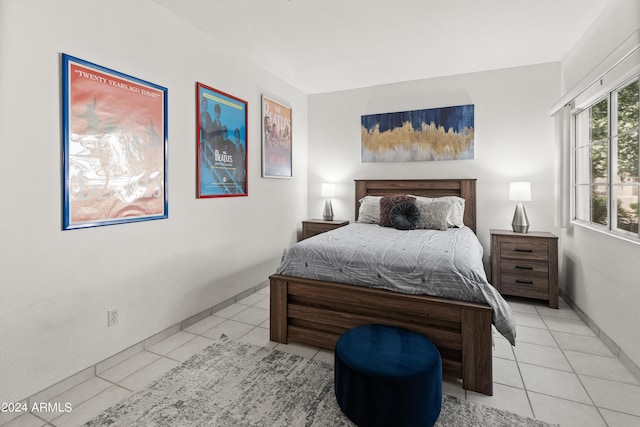 bedroom with light tile patterned flooring and baseboards