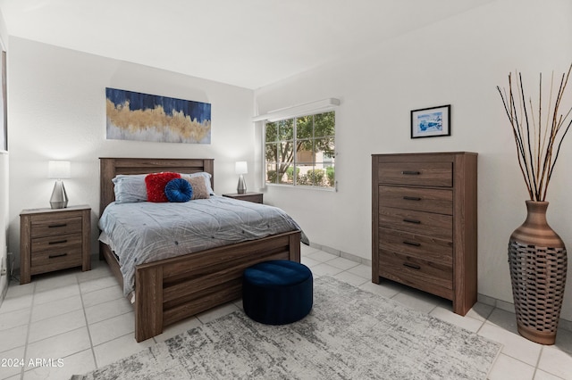 bedroom featuring light tile patterned floors and baseboards