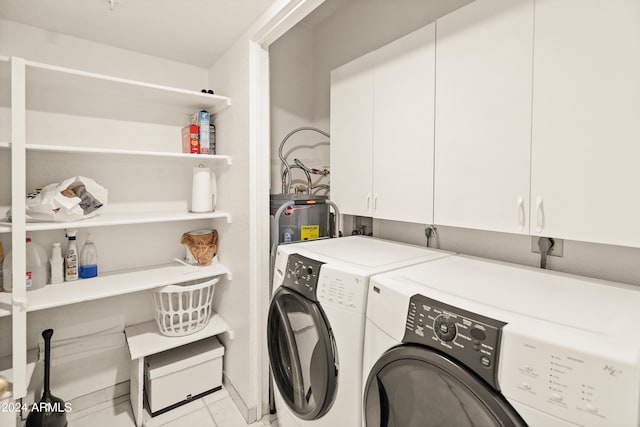 washroom featuring light tile patterned flooring, cabinet space, electric water heater, and separate washer and dryer