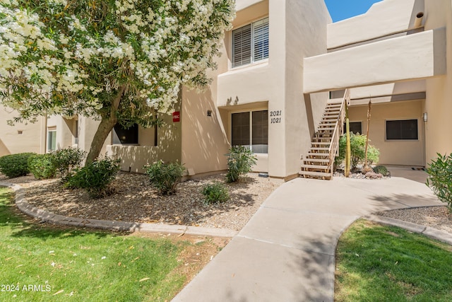 view of front of property with stairway and stucco siding