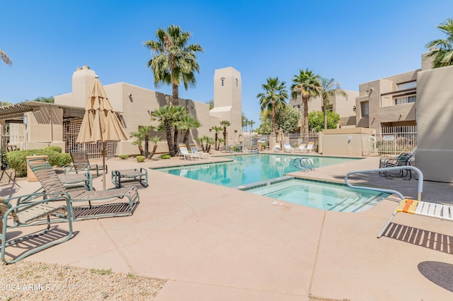 community pool with a patio area, fence, a pergola, and a hot tub