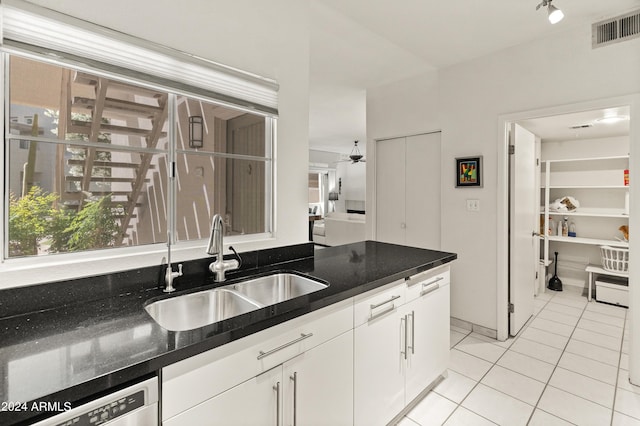 kitchen featuring visible vents, dishwasher, light tile patterned floors, white cabinetry, and a sink