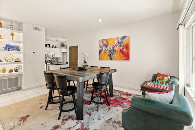 dining space with light tile patterned flooring, baseboards, and visible vents