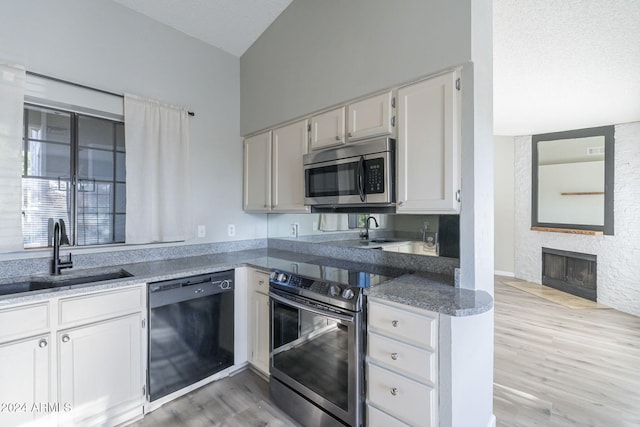 kitchen featuring white cabinetry, sink, appliances with stainless steel finishes, and light hardwood / wood-style flooring