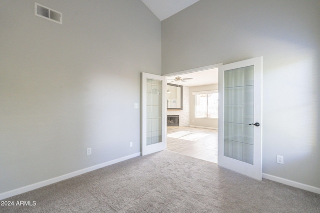 spare room featuring french doors, light colored carpet, and ceiling fan