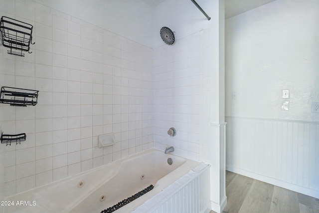 bathroom with tiled shower / bath combo and hardwood / wood-style flooring