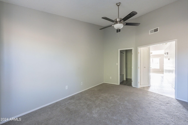 spare room with ceiling fan, carpet floors, and a high ceiling