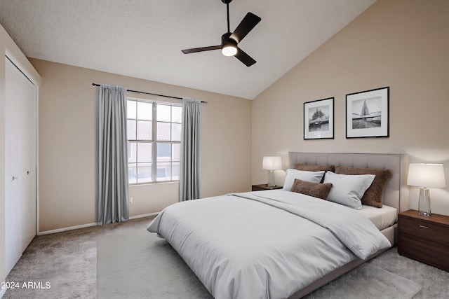 carpeted bedroom with ceiling fan, lofted ceiling, and a closet