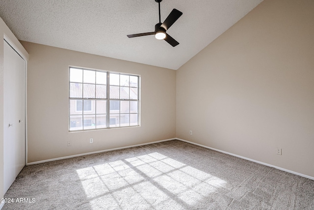 unfurnished bedroom featuring vaulted ceiling, light colored carpet, a closet, and ceiling fan