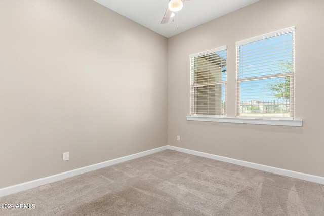 empty room featuring ceiling fan and light colored carpet