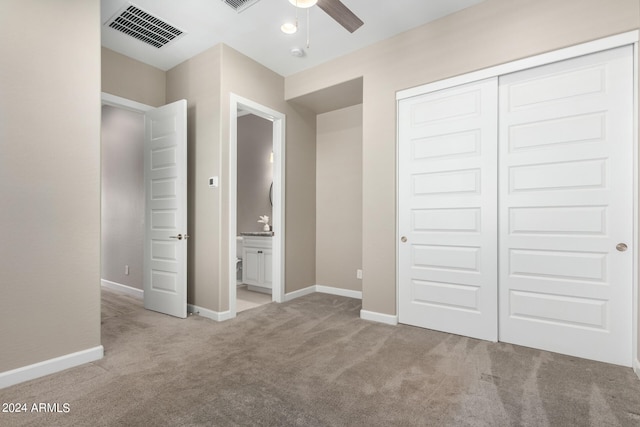 unfurnished bedroom featuring ceiling fan, light carpet, and a closet