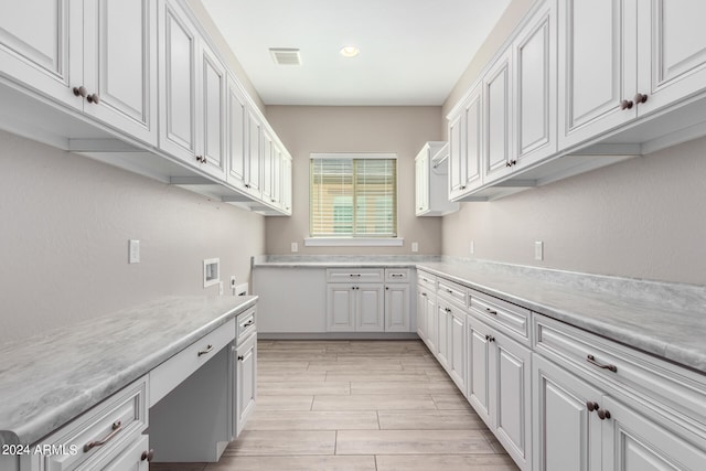 kitchen with light hardwood / wood-style flooring and white cabinets