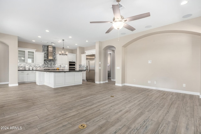 kitchen with pendant lighting, light hardwood / wood-style flooring, white cabinetry, stainless steel appliances, and ceiling fan with notable chandelier