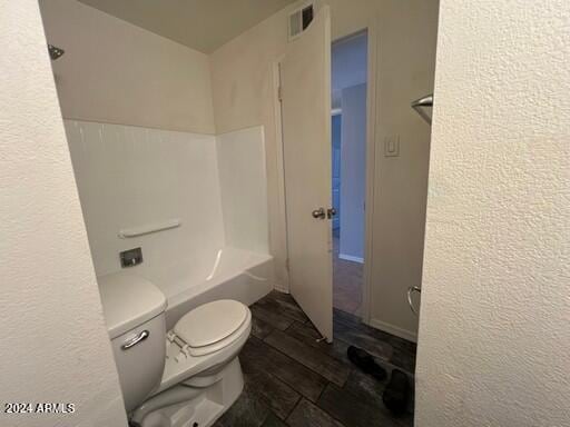 bathroom with toilet, wood-type flooring, and bathtub / shower combination