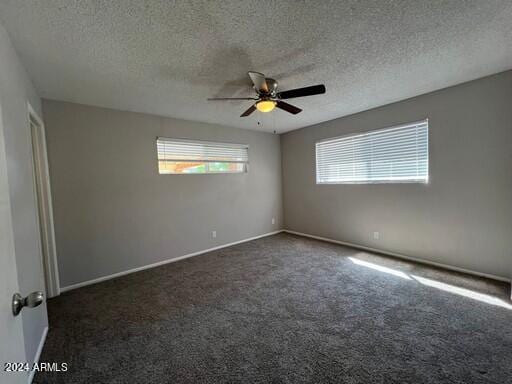 empty room featuring ceiling fan, a wealth of natural light, and a textured ceiling