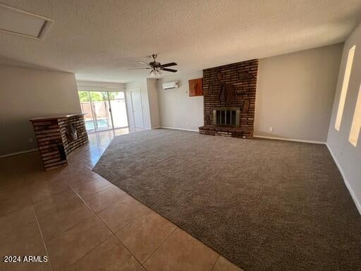 unfurnished living room with a textured ceiling, carpet, ceiling fan, and a brick fireplace