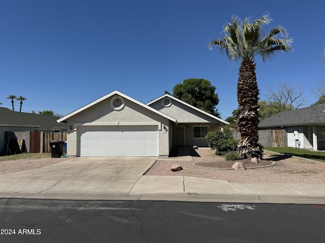 ranch-style house featuring driveway, an attached garage, and stucco siding