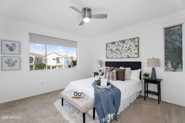 carpeted bedroom with a ceiling fan and baseboards