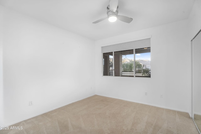 unfurnished room with carpet, baseboards, and ceiling fan