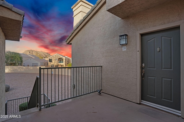 entrance to property with a balcony and stucco siding