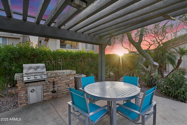 view of patio featuring an outdoor kitchen, area for grilling, fence, a pergola, and outdoor dining space