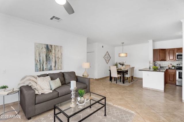 living room featuring ornamental molding, visible vents, ceiling fan, and light tile patterned floors