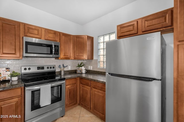 kitchen featuring brown cabinetry, stainless steel appliances, backsplash, and light tile patterned flooring