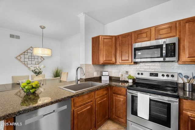 kitchen featuring appliances with stainless steel finishes, visible vents, a sink, and decorative backsplash