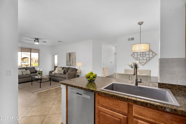 kitchen featuring light tile patterned floors, visible vents, dishwasher, dark countertops, and a sink