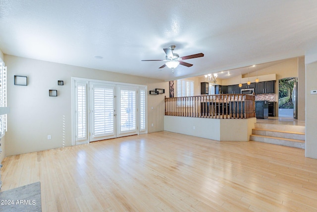 unfurnished living room featuring wood-type flooring, a textured ceiling, and ceiling fan