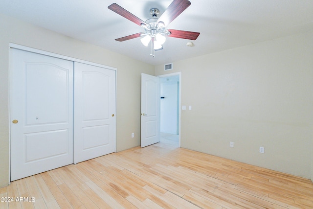 unfurnished bedroom featuring a closet, light wood-type flooring, and ceiling fan