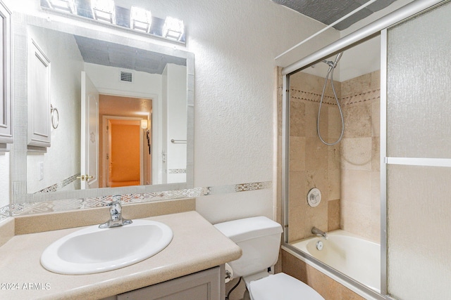 full bathroom featuring combined bath / shower with glass door, vanity, and toilet