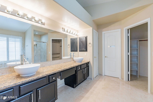 bathroom with tile patterned flooring, a shower with door, and vanity