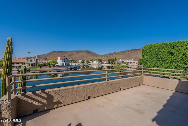 view of patio with a balcony and a water and mountain view