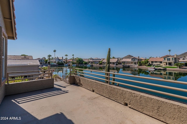 view of patio featuring a balcony and a water view