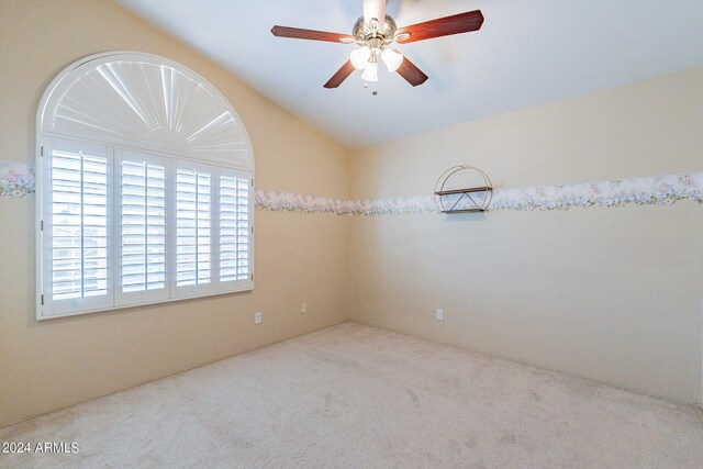 empty room featuring carpet flooring, lofted ceiling, and ceiling fan