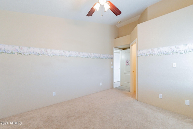 empty room with lofted ceiling, light carpet, and ceiling fan