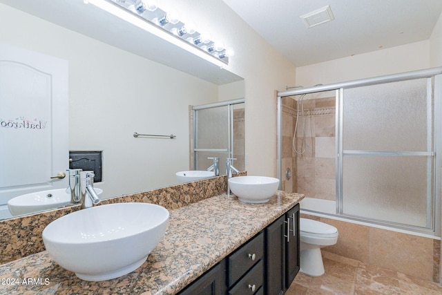 full bathroom with toilet, vanity, and combined bath / shower with glass door