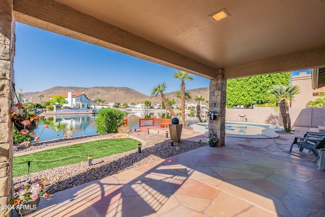 view of patio featuring a water and mountain view