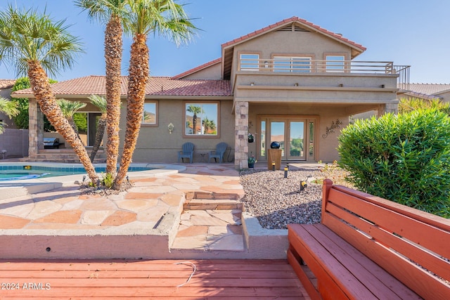 rear view of house with a patio and a balcony