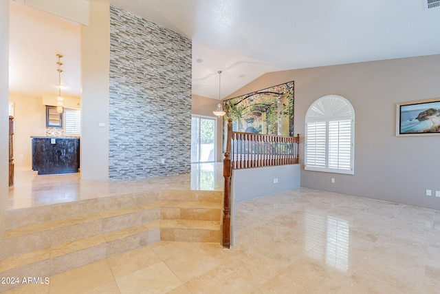 unfurnished room with lofted ceiling and a chandelier