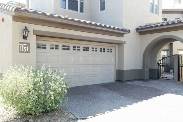 garage with concrete driveway and a gate