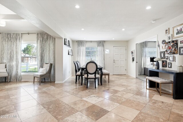 dining space featuring stone tile floors, recessed lighting, baseboards, and a wealth of natural light