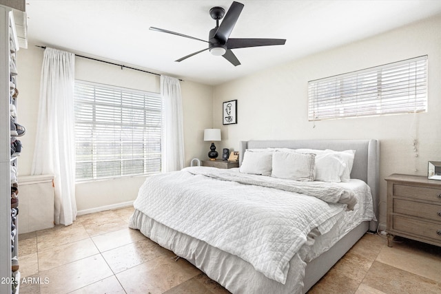 bedroom with baseboards, a ceiling fan, and light tile patterned flooring