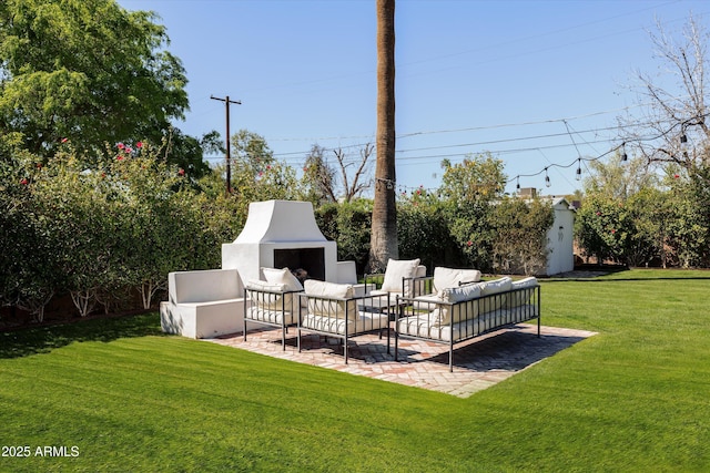view of yard featuring a patio area and an outdoor living space with a fireplace