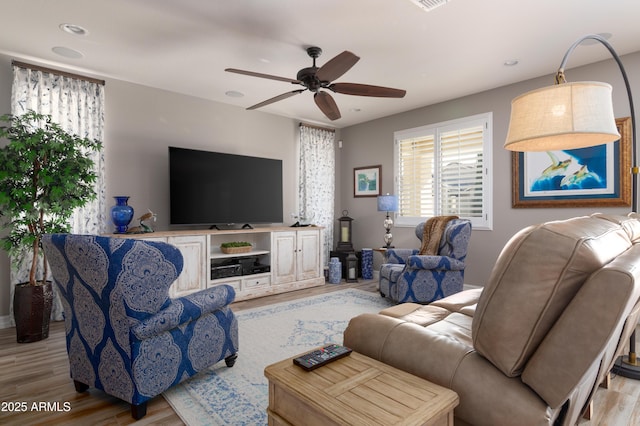 living room featuring light hardwood / wood-style floors and ceiling fan