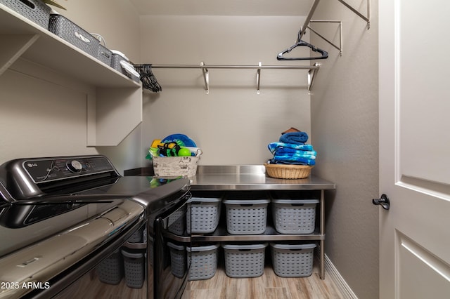 clothes washing area with wood-type flooring and washing machine and clothes dryer